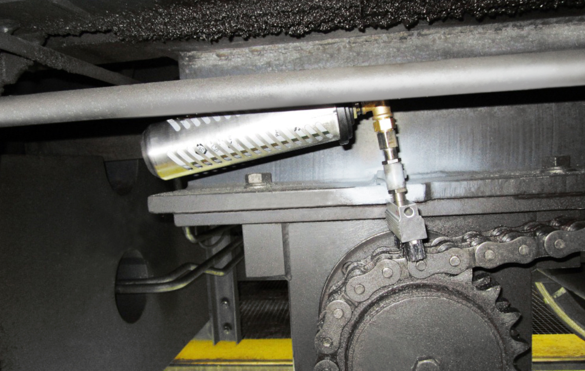 La chaîne d'entraînement d'une grue pivotante sur rails est installée avec un graisseur simalube de 250 ml, y compris les brosses, afin de la lubrifier et de la nettoyer automatiquement.